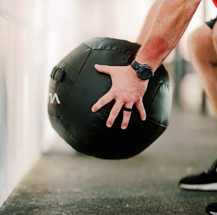 man training with a wall ball at the gym